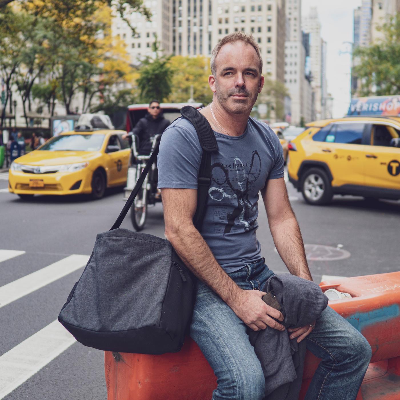 Tom Butler sat in a New York road with yellow taxis in the background