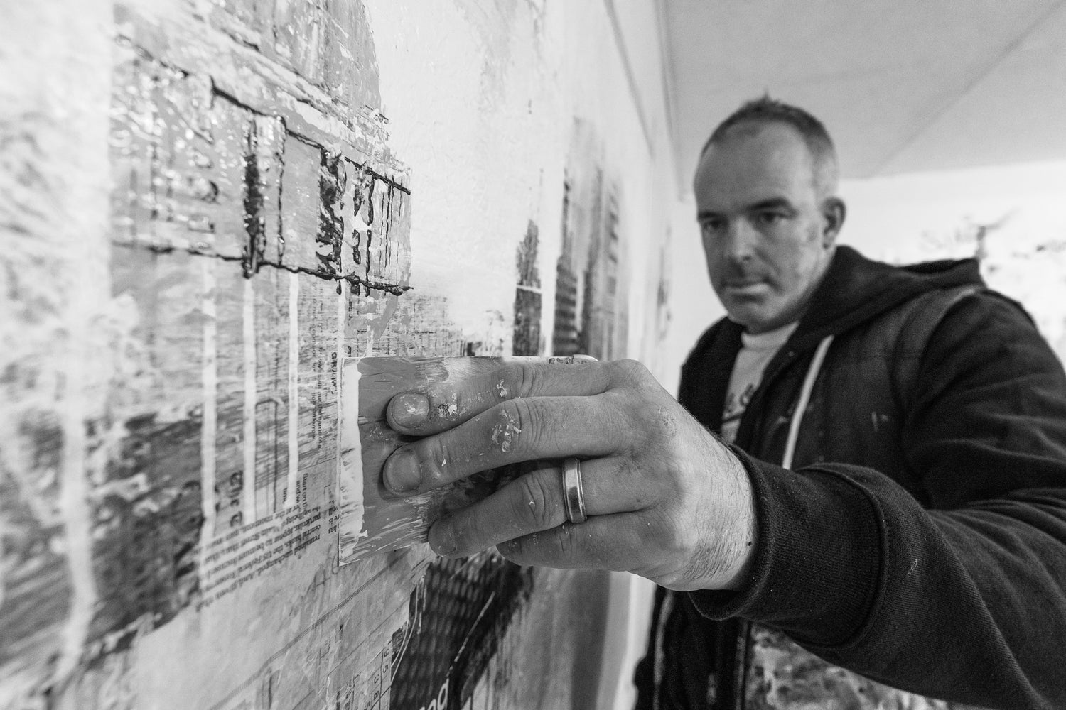 Tom Butler scraping paint to create a textured effect on one of his paintings